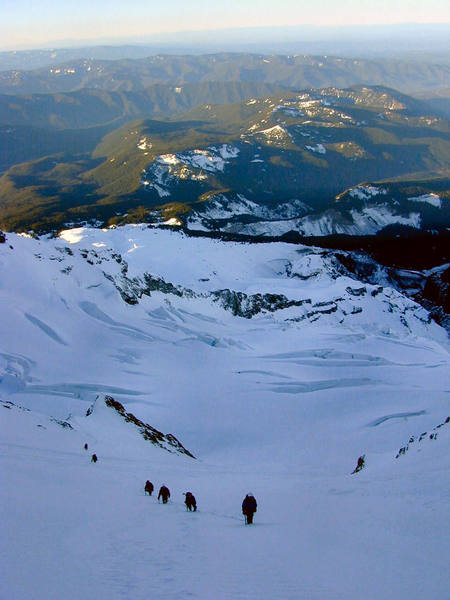 Climbers ascend into Leuthold Couloir with Reid glacier below.