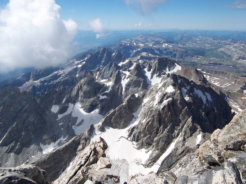 Looking south from the Grand Teton summit. From right to left: Middle Teton, South Teton, Icecream Cone, Spalding Peak, Gilkey Tower, Cloudveil Dome, Nez Perce. The two big peaks in the background are Mt. Wister and Buck Mountain.