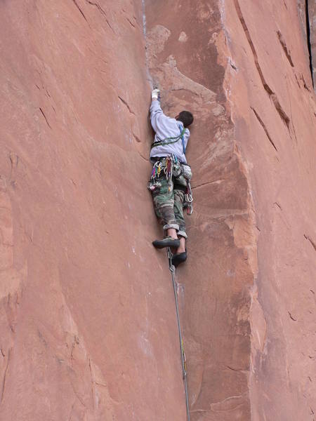 Tony Romano protects before sending the crux where the crack thins out to small fingers.  Some climbers use the arete for help, others use small face holds on the left for help.