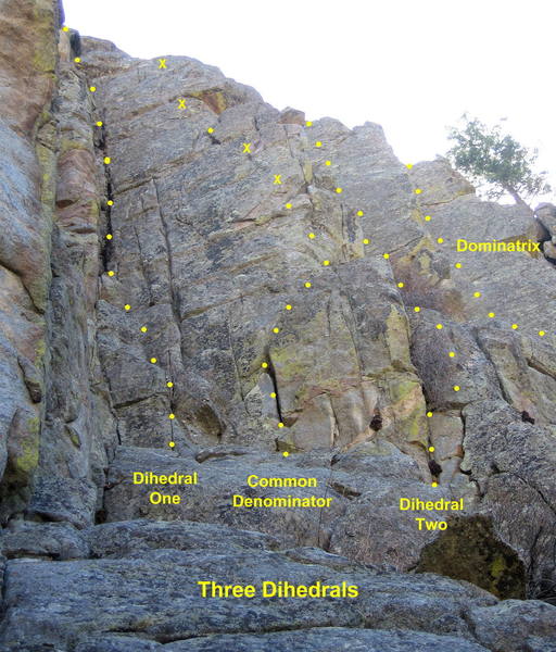 Three Dihedrals. All climbs start at the base of a low-angle ramp. <br>
<br>
Dihedral One takes the steep corner on the left. (5.7)<br>
<br>
Common Denominator climbs the arete and face right of Dihedral One. (5.9+)<br>
<br>
Dihedral Two climbs the bushy corner right of Common Denominator. (5.8)<br>
<br>
Dominatrix is the third dihedral; it starts uphill on the right. (5.8 or 5.10)