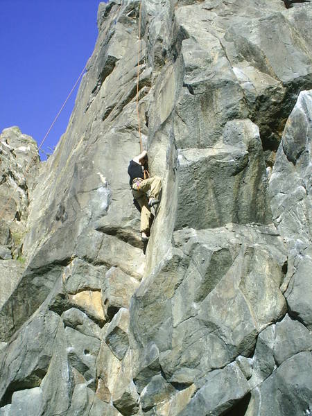 My brother struggling at the crux of "Kindling Crack", one of the classic routes at Long Beach (Dunedin area).