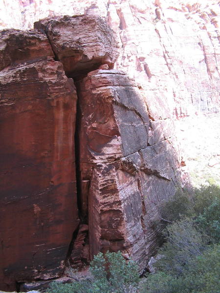 The Exsqueeze Me tight chimney. In the sun on the right side is part of the scramble/solo to gain the top of the formation if you want to set up a toprope.