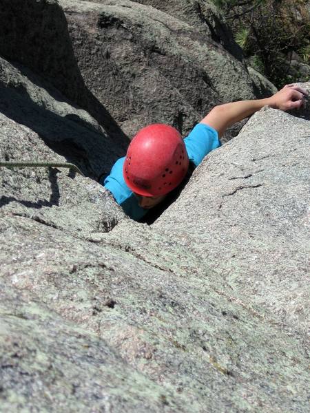 Anna Clarke finishes the great hand jam section with right side in and left out on a bucket on the arete. This is the end of challenging climbing on P1.