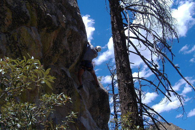 Pulling through the juggy roof to access the "great face climbing above."