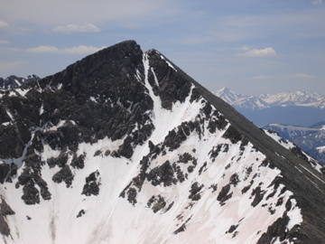 Beta shot I took from the ridge between Father Dyer and Crystal Peaks on June 4th, 2006. The couloir splits the face and ends in the notch. I climbed it two weeks later and the snow was perfect with just a little ice forming in the narrow upper section.