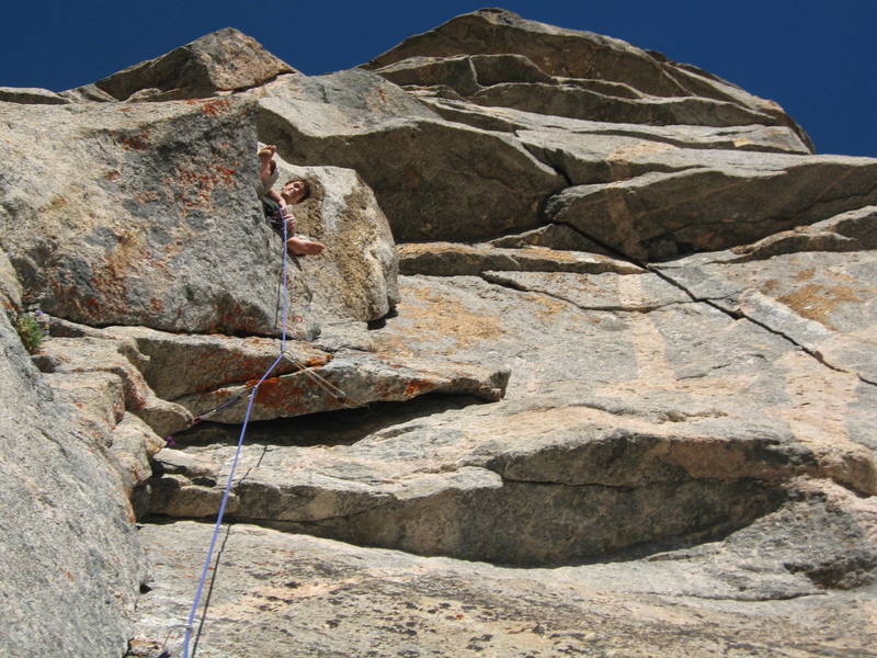 Looking up at the fine belay ledge at the top of pitch 2. The 11c face traverse starts right off this ledge, goes to the crack, and then more 5.11 thru the roof.