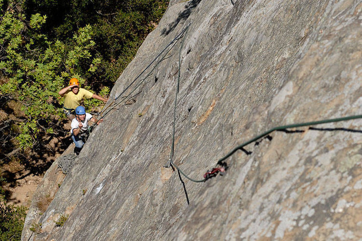 Another way of doing things: lately, when I am taking inexperienced climbers up Face Lift, I climb the pictured variation. This variation involves pulling up early on the first pitch and belaying from a comfortable ledge. The second pitch bypasses the usual belay stance altogether and climbs straight up from the route's fourth bolt and passes another bolt to gain an obvious ledge with trees. While this is seriously runout for the leader, it is much less likely to produce a serious pendulum for the second. I believe that this variation follows the upper portion of the route known as "Tigger Treat" (5.8) in the Edward's Guidebook.