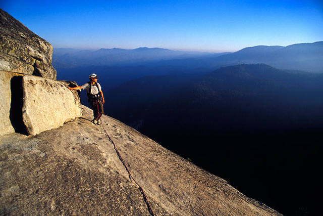 Matt Grieger takes in the view from 11 pitches off the deck as smoke from a rapidly building fire casts an eary glow. The Magician Needle.<br>
www.EarthworksImagery.com