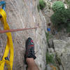 At the anchors of Animation on animal World, a GREAT climb, looking down at Robin belaying and David relaxing