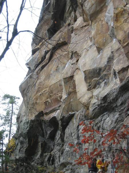 Beat Junkie climbs near the skyline. The start can be recognized by the long yellow draw in shaded rock. The Skewer fingercrack splits the wall above. From there, the climb angles right through tiered roofs.