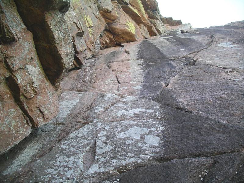 Crazy Alice climbs the zig-zag cracks to the right of the black water streak. The Dihedral is on the left.