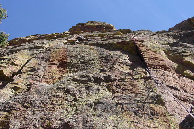 The traverse is easy until this point, when it gets slightly dicey. I'm climbing with double ropes. The left, blue, rope is clipped to the big cam at the top of the wide crack. I climbed several placements from there on the right, red rope, then clipped the blue to the sling over the horn midway across the traverse. I clipped the red after making the first hard move up the left crack. Rope drag was minimal this way, but the ropes are still heavy by the end of this long pitch.<br>
<br>
Photo by Paul Rezucha.