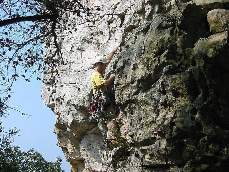 Trying hard to blend with the color of the rock, I move up to the traverse on Pin Chimney.