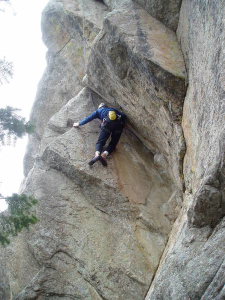 Switching feet to get the left foot onto a thin edge. The finishing jug is higher on the arete above Luke's left hand.