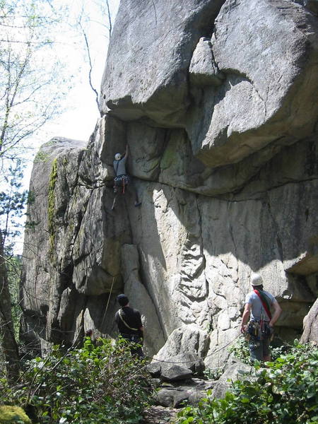The climber is on Orphan (5.9). Block and Tackle (5.11b) takes the weakness through the main overhang.