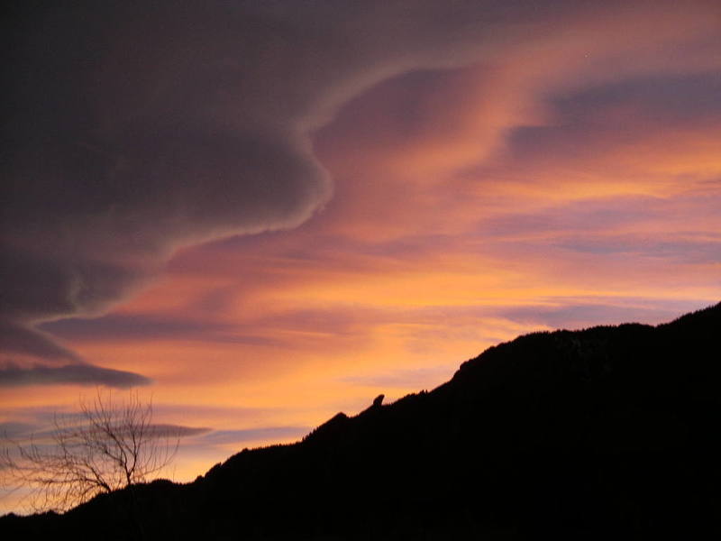 Clouds at sunset above the Flatirons. Devil's Thumb visible in the skyline.
