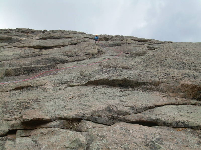 Jon Tashkin on one way to do P1. Start above the dead tree. You can weave right about 60' up to a couple ratty, purple slings, then up to a undercling, then, left to the corner again. A 60m pitch gets you to the left end of the overhang. The climbing is Flatiron-esque.