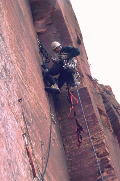 Tony Bubb searches for the right piece to fit in the arch pitch of Prodical Son (IV, C2) in Zion National Park. Photo by Mary Ann Dornfeld, 2004.