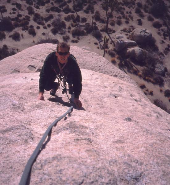 Chris Parks follows on Mike's Books (5.6) at Jtree's Intersection Rock. The easy, but runout slab finish was a good intro to the area. Photo by Tony Bubb 1/03.