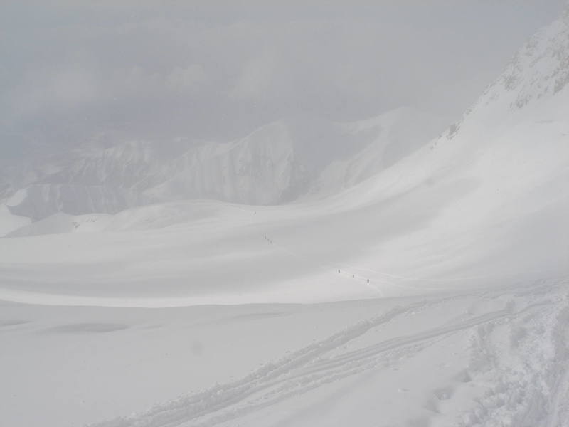 Looking down the route from Windy Corner toward Squirrel Point, as climbers make their way up from 12,000 feet. This stretch can be wonderfully sunny or brutally windswept, and may be snow covered (as in this photo) or an exposed scree field. There's a reason they call it Windy Corner. Guided teams commonly cache loads along this stretch and descend to "sleep low" in the camp at 11.300 feet.