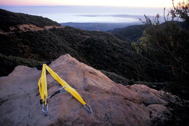 This is likely the worst anchor I've ever seen.  The yellow "webbing" in the photo is actually a strap from the climber's SUV roof-rack.  It's hard to see in this photo, but 2 rubber-ized hooks on the two ends of the strap are hooked through the left-hand carabiner.<br>
<br>
The anchor is completely non-redundant and relies on the stitching that attaches the rubber-ized hooks to the ends of the strap.  And that quick-draw?<br>
<br>
At least they padded the edge to protect the strap from abrasion.