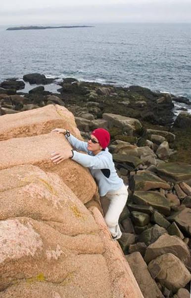 Issa topping out a highball slab amidst the jumble of amazing blocks lining the coast.
