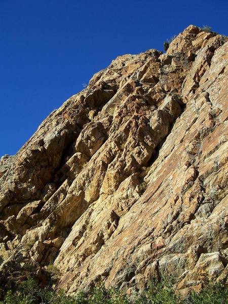 Little Feat starts out in the corner and stays on the sunny face to the right. Once on the ledge above, follow protection opportunities to the top of the cliff.