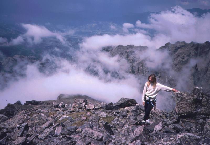 Sarah Shull hangs out on the summit of Sharkstooth. Although this is the highest summit in the park that lacks a "non-technical" ascent route, it is easily accessible by rock graded at 5.6.<br>
<br>
Photo by Tony Bubb, 1996.