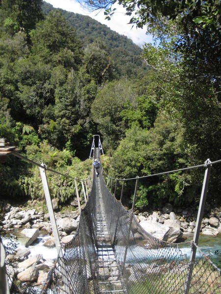 Natalie crossing one of a dozen classic kiwi swing bridges on the Copland Valley trail.