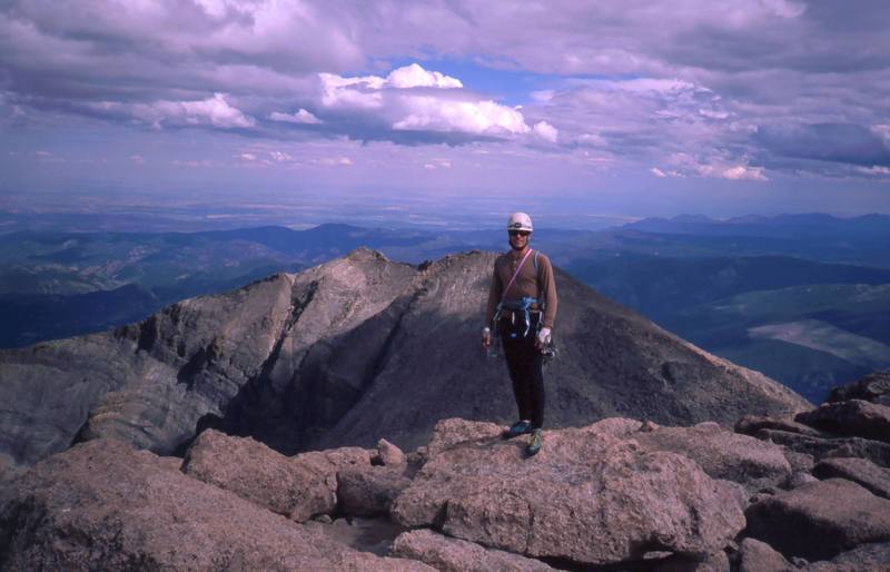 Tony Bubb on the Summit of Long's Peak, with Meeker in the Background. The prominent ridge low and left is the Flying Buttress. Photo by Joseffa Meir, 2001.