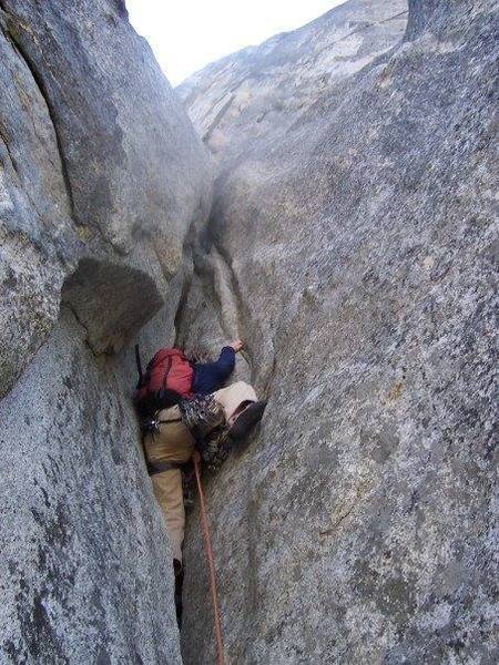 Unfortunately, this pitch is simply known as "the pitch after the Wilson Overhang."  You'll definitely want to go for the flake/face climbing to the right of the squeeze!