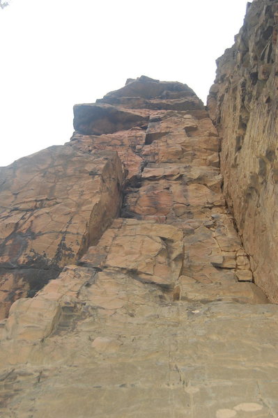 Mind bender follows the center of the slab to the right facing corner- 1st crux is negotiating the large block 1/2 way up- 2nd is pulling over the small roof