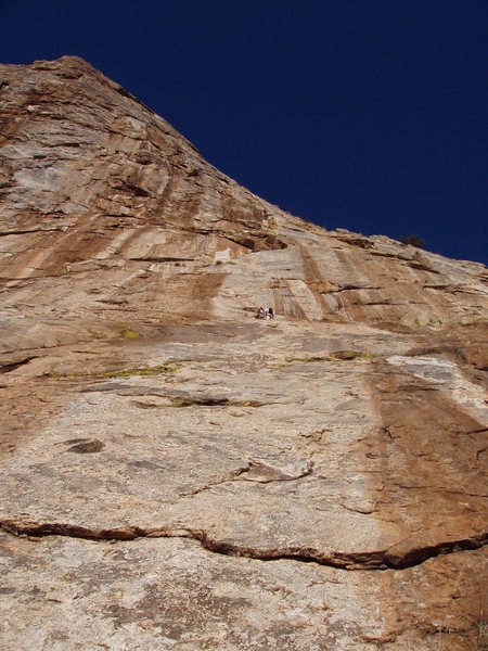 Looking up at the Pitch 1 with climbers at top of pitch.