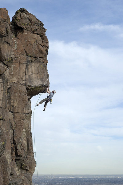 A climber working his way over the giant overhang high above Denver.