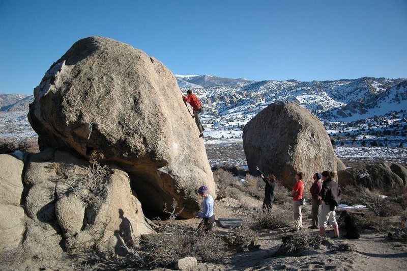 Vicken Hillis on an unnamed v0 on the Buttermilk Stem Boulder. Rowell Rock is to the right and behind.
