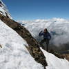 Contemplating the steep snow-covered terrain ahead without ice axe and helmet, Nancy Bell just below her high point on the Normal Route, Illiniza Norte. After this, we turned around and summited via the descent route. Cotopaxi can bee seen on the horizon.
