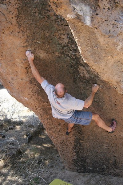 Mike reaching up left to the sharp crimp on Funnel Man, V9.