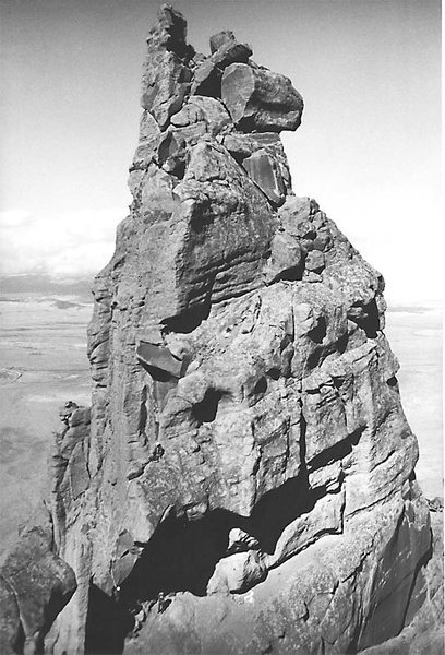 A view of the main summit from the south summit. Note the climbers on the horn pitch in the lower-left part of the photograph. Taken during the "Ship Rock 30th anniversary ascent" in 1969, just before the closure.