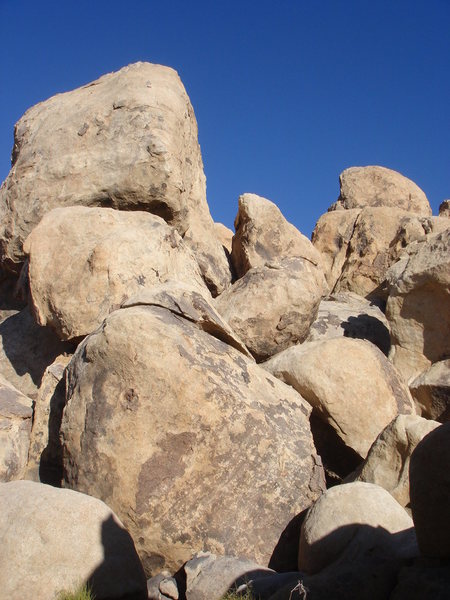 Looking up the boulder field that leads to the Evil Pillar. In the lower right corner of the photograph you can see an opening. Enter this "cave" and continue to the end. From there, scramble up to the left to reach the base of the routes.