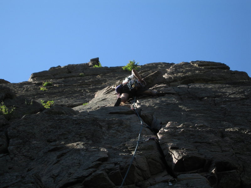 Don Owens stepping right to gain the first belay ledge ~10 feet above him. Note how well the crack takes pro on the first pitch.