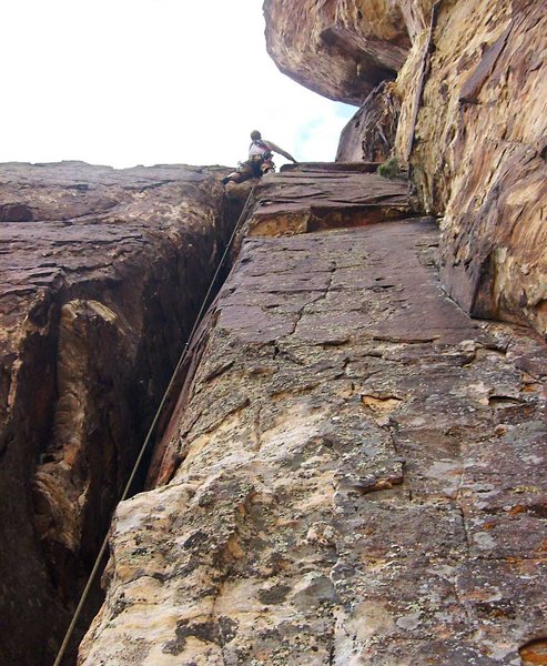 At the top of the chimney on the third pitch. The ominous corner crack of looms above on the right.