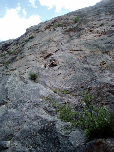 Contemplating the tricky move up to the crux.