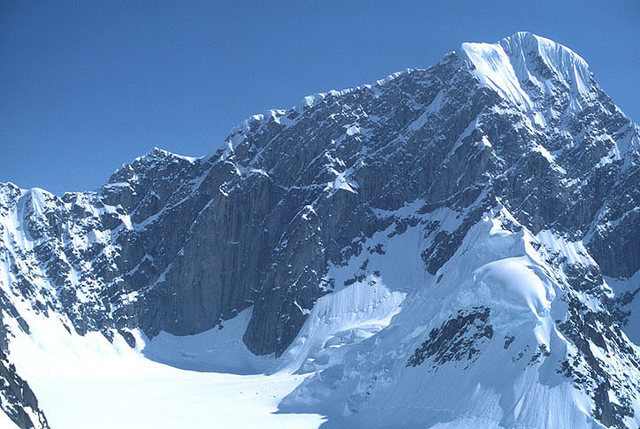 The west face of Mt. Huntington from the Upper Tokasitna. The Harvard route ascends this wall on the right side of the photo to the sunlit shoulder. The left (NW) ridge is the first ascent route.