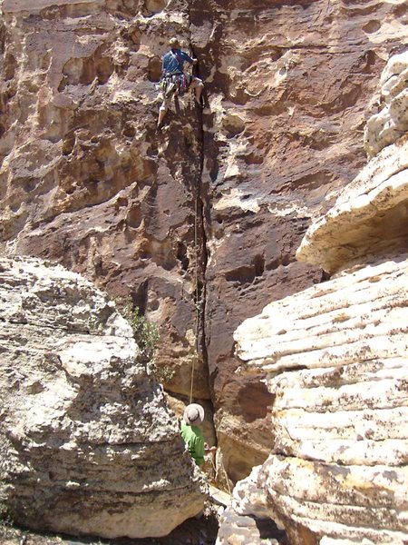 Getting started; the belayer leans back against the oversize cheatstone.
