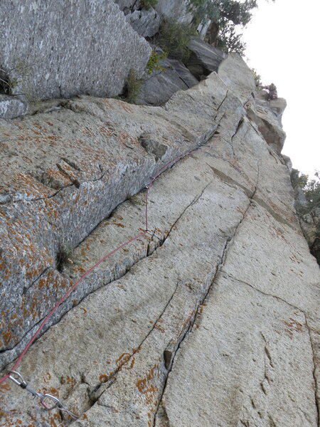 Looking up at Pudgy Gumbies from the belay. When you stand at the base in person, you can see a pin about 25' up in the left facing ramp.