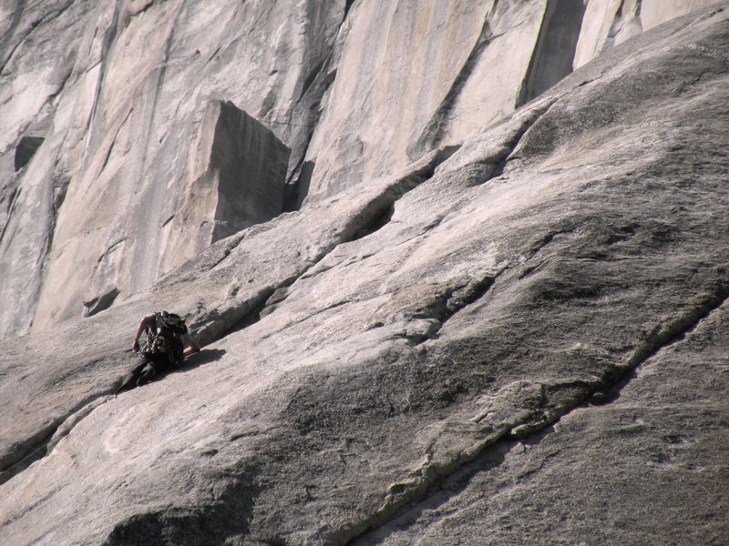 Climber on the first pitch of the Nose while El cap spire looms in the distance