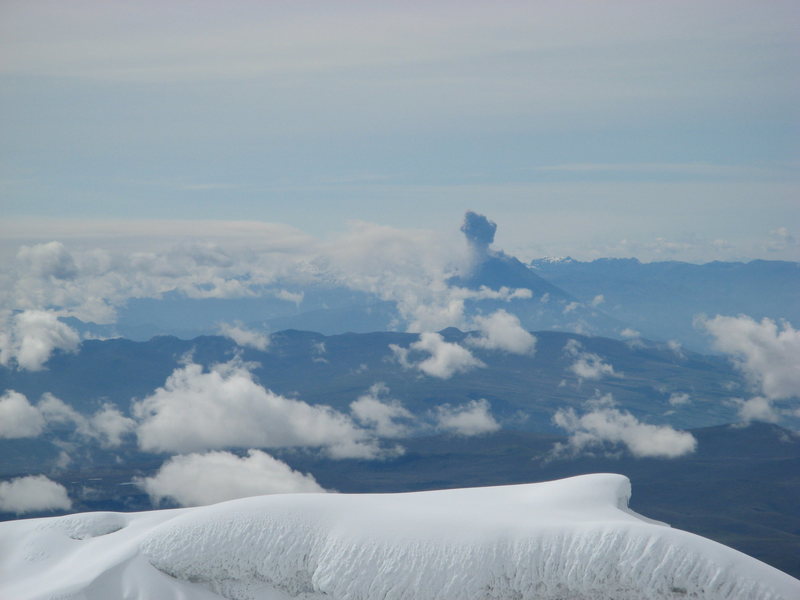 Tungurahua volcano erupting in the distance as seen form the summit of Volcan Cotopaxi. Jan, 11, 2008