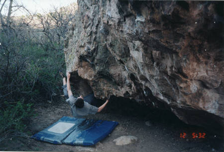 Jeff Russell bouldering the V2-ish line starting to his right, back in the darkness right about where the time-stamp is on the pic.