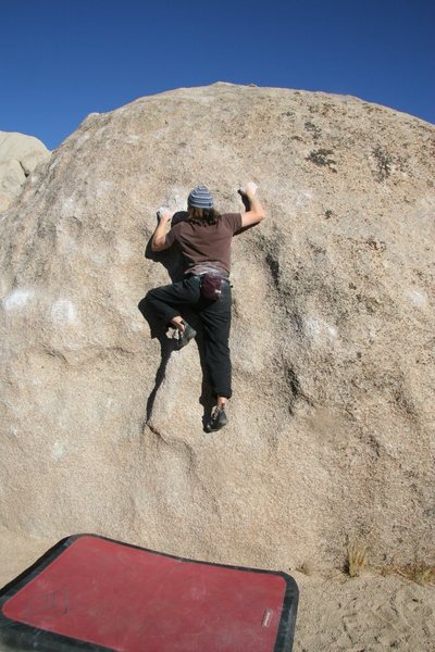 Finishing the crux and getting onto the easier slab above.