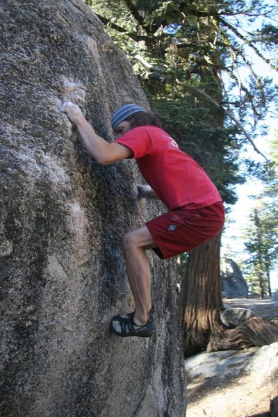 Reaching up to the better holds on the arete of Knobs Problem, V2